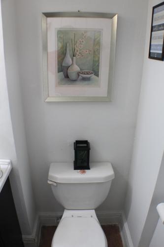 a bathroom with a white toilet with a clock on it at Southend Gem in Hartford