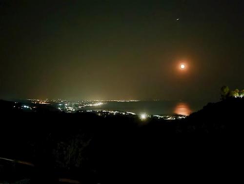 a view of a city at night with the moon at Karma Rural Buenavista in Santa Marinella