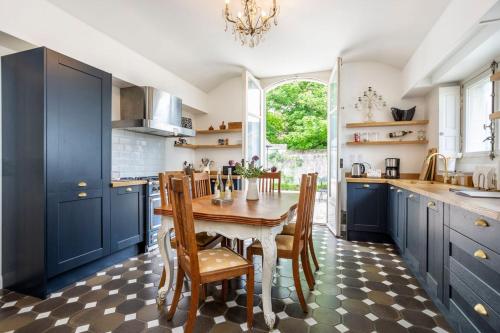 une cuisine avec des armoires bleues et une table et des chaises dans l'établissement Palais D’Or, à Loches
