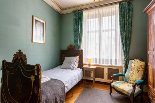 une chambre avec un lit, une chaise et une fenêtre dans l'établissement Palais D’Or, à Loches