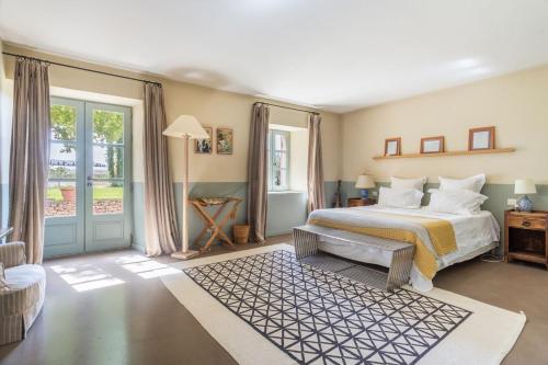 - une grande chambre avec un lit et une fenêtre dans l'établissement Les Deux Mas, à Lagnes