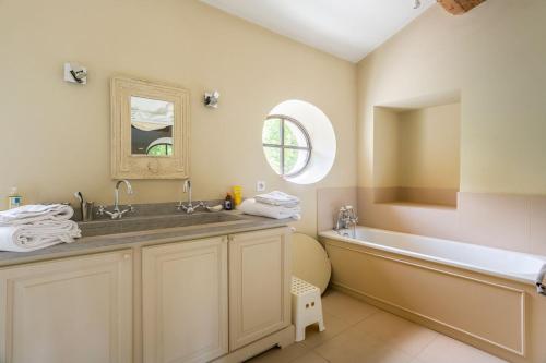 une salle de bain avec une baignoire et un lavabo et une baignoire dans l'établissement Les Deux Mas, à Lagnes