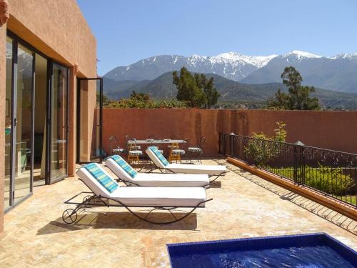 a patio with lounge chairs and a swimming pool at Villa Gourza in Tassa Ouirgane