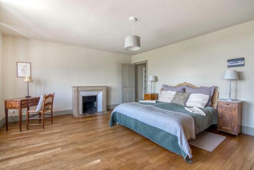 - une chambre avec un lit, un bureau et une cheminée dans l'établissement Manoir Des Chasseurs, à Saint-Prix
