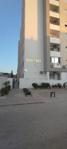 a building with a sign on the side of it at ConfortTek apartment in Boumhel El Bassatine