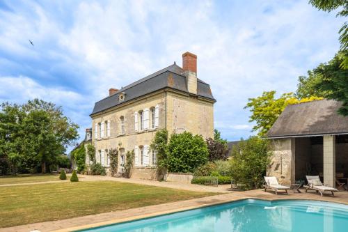 une vieille maison avec une piscine en face de celle-ci dans l'établissement Manoir Des Arts, à Allonnes