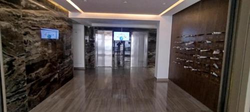 a hallway with a wall of wine bottles at ConfortTek apartment in Boumhel El Bassatine