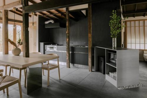 a kitchen with a table and a dining room at 紡ノ座 築100年 一日一組限定のモダン古民家ステイ in Nagara