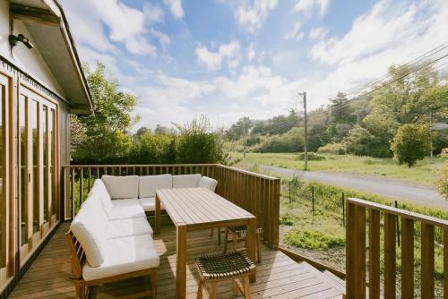 a patio with a couch and a table on a deck at 紡ノ座 築100年 一日一組限定のモダン古民家ステイ in Nagara