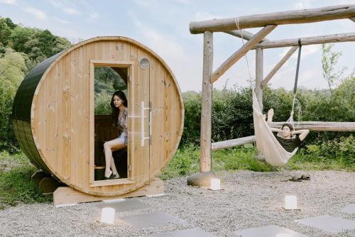 a man and a woman sitting in a round wooden play house at 紡ノ座 築100年 一日一組限定のモダン古民家ステイ in Nagara