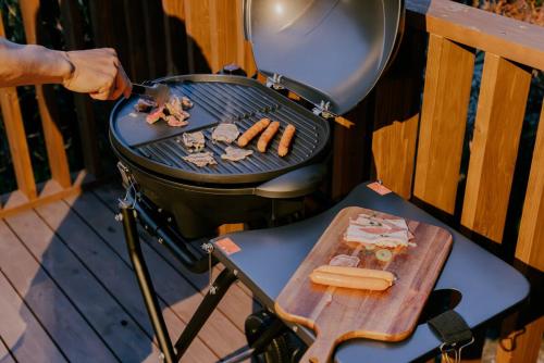 a person cooking hot dogs on a grill at 紡ノ座 築100年 一日一組限定のモダン古民家ステイ in Nagara