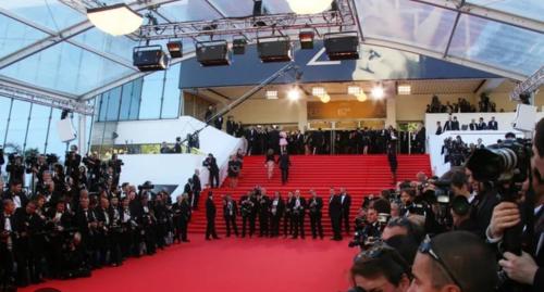 un grand groupe de personnes debout sur un tapis rouge dans l'établissement Cannes La Croisette, à Cannes