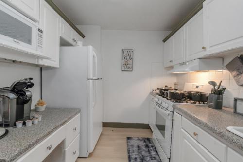 a kitchen with white cabinets and a white refrigerator at Modern 3BR Condo - Heart of ATL in Atlanta