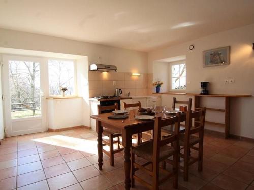 a kitchen with a wooden table and chairs in it at Gîte rénové au calme avec Parking privé et Wifi gratuit à Saint-Étienne-Lardeyrol - FR-1-582-332 in Saint-Étienne-Lardeyrol