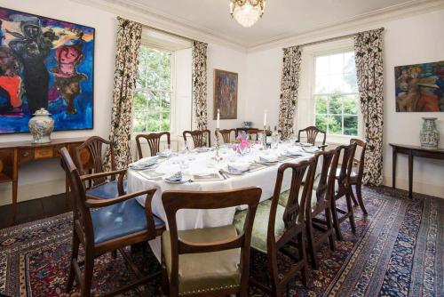 a dining room with a long table and chairs at Wallace House in Innerleithen