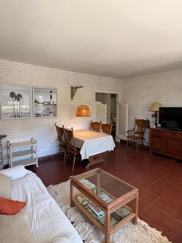 a living room with a table and a couch at Dpto en Playa Grande in Mar del Plata