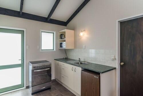a kitchen with a sink and a stove at Avana Suites in Lower Hutt