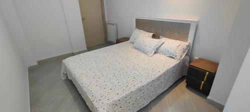 a bedroom with a bed with white sheets and pillows at holiday apartment 3 in Jijel