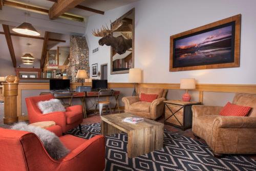 a living room with red chairs and a table at Evergreen Lodge at Vail in Vail