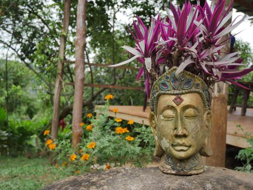 a statue of a head with flowers on a rock at Hostal El Silencio Vivo in San Rafael