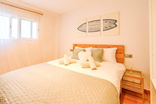 una camera da letto con un letto con due orsacchiotti sopra di Ayora Penthouse - Jacuzzi, Huge Private Rooftop, BBQ, Sunset Views, FastWifi, AC a Valencia