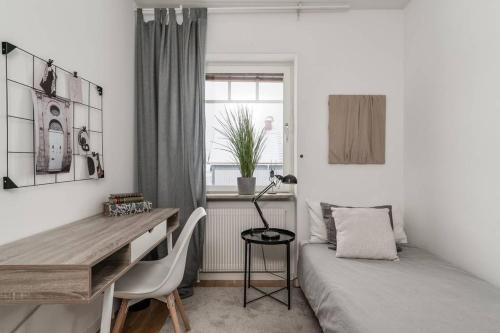 a bedroom with a desk and a bed and a window at Gylle Luxe Retreat in Borlänge