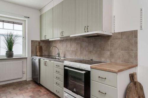 a kitchen with white cabinets and a sink at Gylle Luxe Retreat in Borlänge