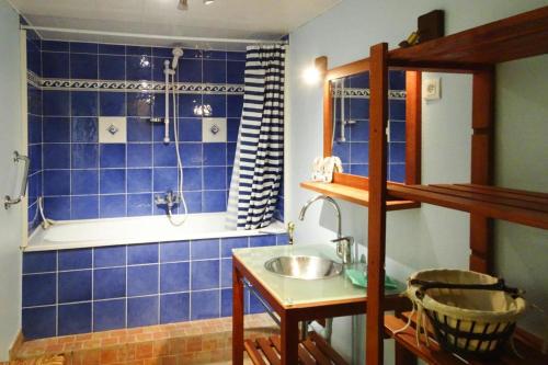 une salle de bain carrelée bleue avec un lavabo et une baignoire dans l'établissement Holiday Home in Quiberville with Sea Views, cleaning included, à Quiberville