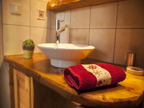 La salle de bains est pourvue d'un lavabo et d'une serviette rouge sur un comptoir. dans l'établissement Mansion in Albertville near Ski Slopes, cleaning included, à Mercury
