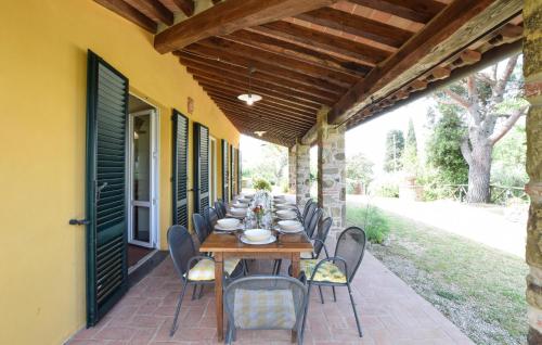 una mesa larga con sillas en el patio en Stunning Home In Lucignano, en Lucignano