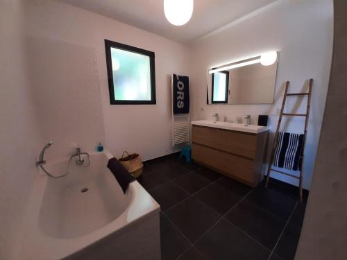 une salle de bain avec une baignoire, un lavabo et un miroir dans l'établissement Villa in Languedoc with Private Pool, cleaning included, à Sainte-Vallière