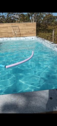 a swimming pool with a hose in the water at Bangalô Sol e Lua - ao lado da portaria do Parque Nacional in Sao Jorge