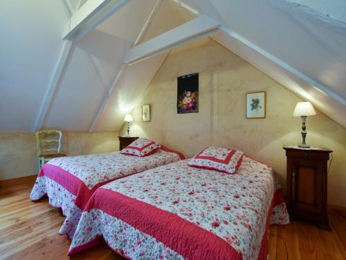 deux lits dans une chambre avec un grenier dans l'établissement Vacation Home in Querrien near Roches du Diable, cleaning included, à Querrien