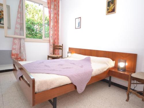 une chambre avec un lit en bois et une fenêtre dans l'établissement Apartment in Mèze near Vineyards & Pool, cleaning included, à Mèze