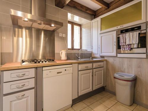 une cuisine avec des armoires blanches et un four à plaques de cuisson dans l'établissement Villa in Sérilhac with Private Pool, cleaning included, à Sérilhac