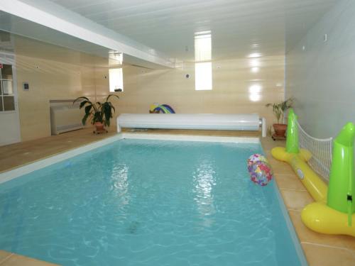 une piscine intérieure avec un toboggan et une piscine dans l'établissement Holiday Home in Vignol with Heated Pool, cleaning included, à Vignol