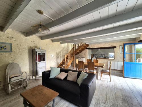 un salon avec un canapé et une table dans l'établissement Stone House in Brittany near Roscoff & Beaches, cleaning included, à Plougoulm