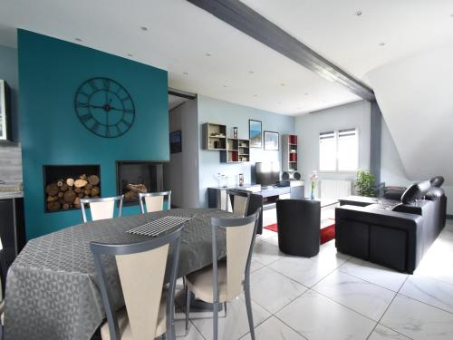 une salle à manger avec une table, des chaises et une horloge dans l'établissement Mansion in Quinéville near Sandy Beach, cleaning included, à Quinéville