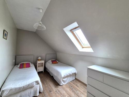 - une chambre mansardée avec 2 lits et une fenêtre dans l'établissement Stone House in Brittany near Roscoff & Beaches, cleaning included, à Plougoulm