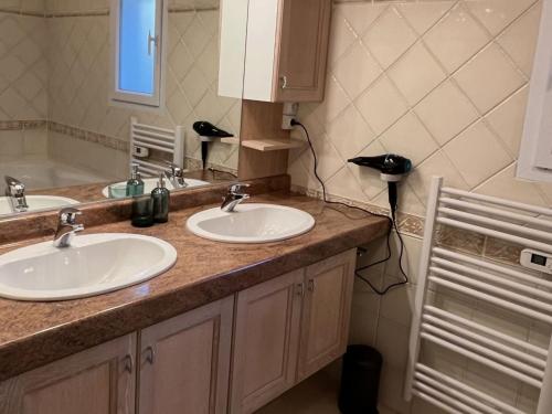 une salle de bains avec deux lavabos et un téléphone sur le comptoir dans l'établissement Holiday Home in Goudargues with Heated Pool, cleaning included, à Goudargues