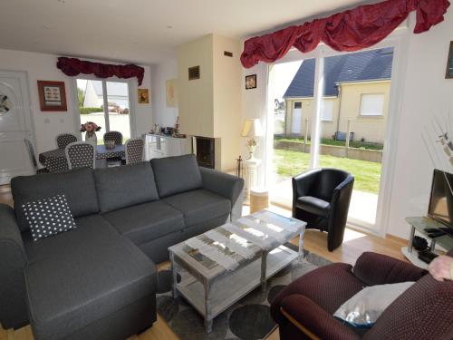 un salon avec un canapé et une table dans l'établissement Holiday Home in Denneville by the Sea, cleaning included, à Denneville