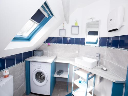 une salle de bain avec une machine à laver et un lavabo dans l'établissement Holiday Home in Quinéville near Beach, cleaning included, à Quinéville