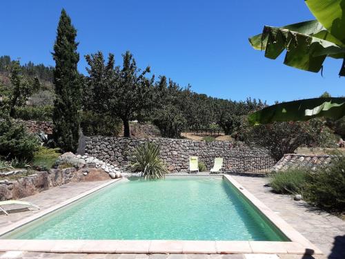 une piscine avec deux chaises et un mur en pierre dans l'établissement Holiday Home in Chambonas for 5 Person, cleaning included, à Chambonas