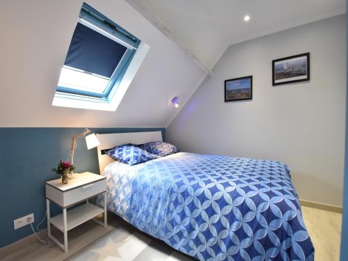 une chambre avec un lit bleu et une fenêtre dans l'établissement Holiday Home in Quinéville near Beach, cleaning included, à Quinéville
