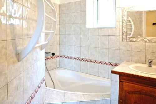 une salle de bain avec une baignoire et un lavabo dans l'établissement Stone cottage with shared pool, Chambonas, cleaning included, à Chambonas