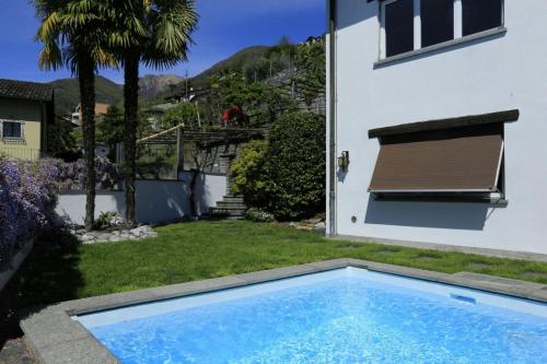 uma piscina no quintal de uma casa em Casa Micheroli em Gordola