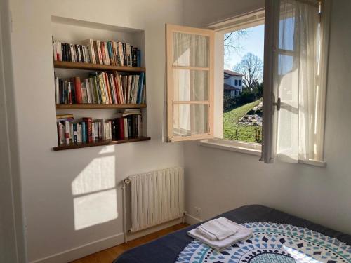 - une chambre avec un lit et une étagère avec des livres dans l'établissement Holiday Home Arcangues near Beaches, cleaning included, à Arcangues