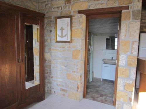 une pièce avec un mur en pierre avec une porte et un lavabo dans l'établissement Charming House in Plouhinec near the Coast, cleaning included, à Plouhinec
