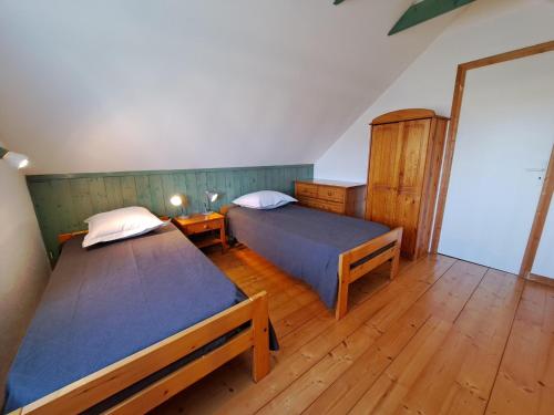 deux lits dans une chambre avec parquet dans l'établissement Holiday Home in Cléder near Amiets Beach, cleaning included, à Cléder