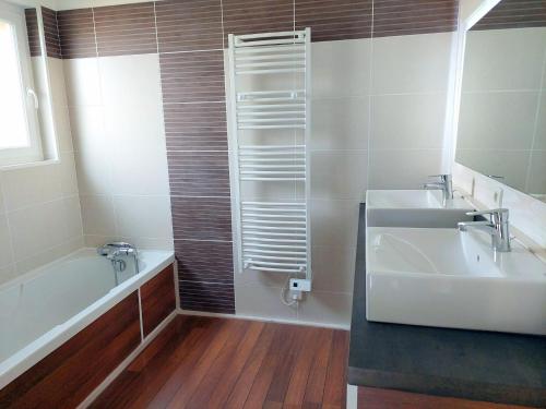 une salle de bain avec une baignoire, un lavabo et un miroir dans l'établissement Holiday Home in Cléder near Amiets Beach, cleaning included, à Cléder